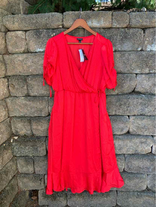 Bright red wrap dress with puff sleeves and ruffle hem, mid-length, lightweight fabric.