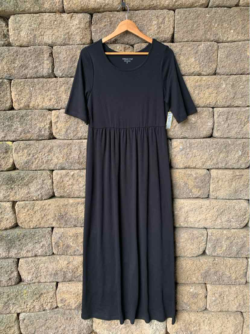 Black short-sleeve midi dress with fitted waist and flowing skirt on wooden hanger.