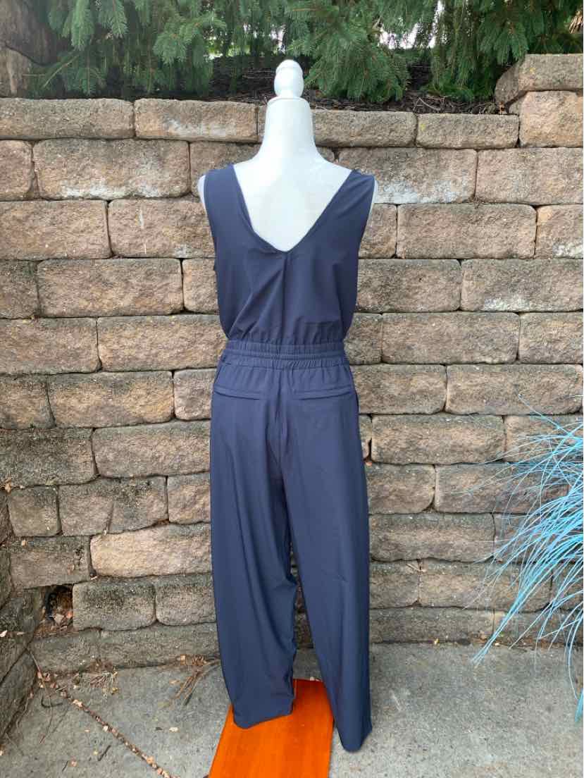 Navy blue sleeveless jumpsuit with V-neck and elastic waistband, lightweight fabric.