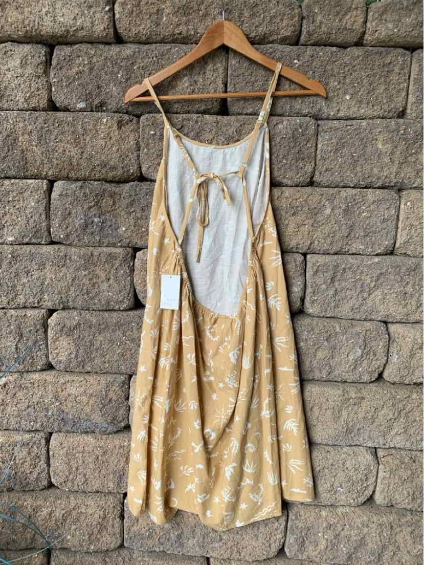 Tan floral midi dress with thin adjustable straps, gathered waist, and front tie detail.