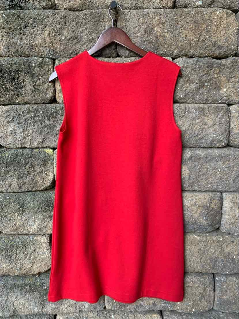 Red sleeveless knit dress with a round neckline and a straight, relaxed fit hanging on a wooden hanger.