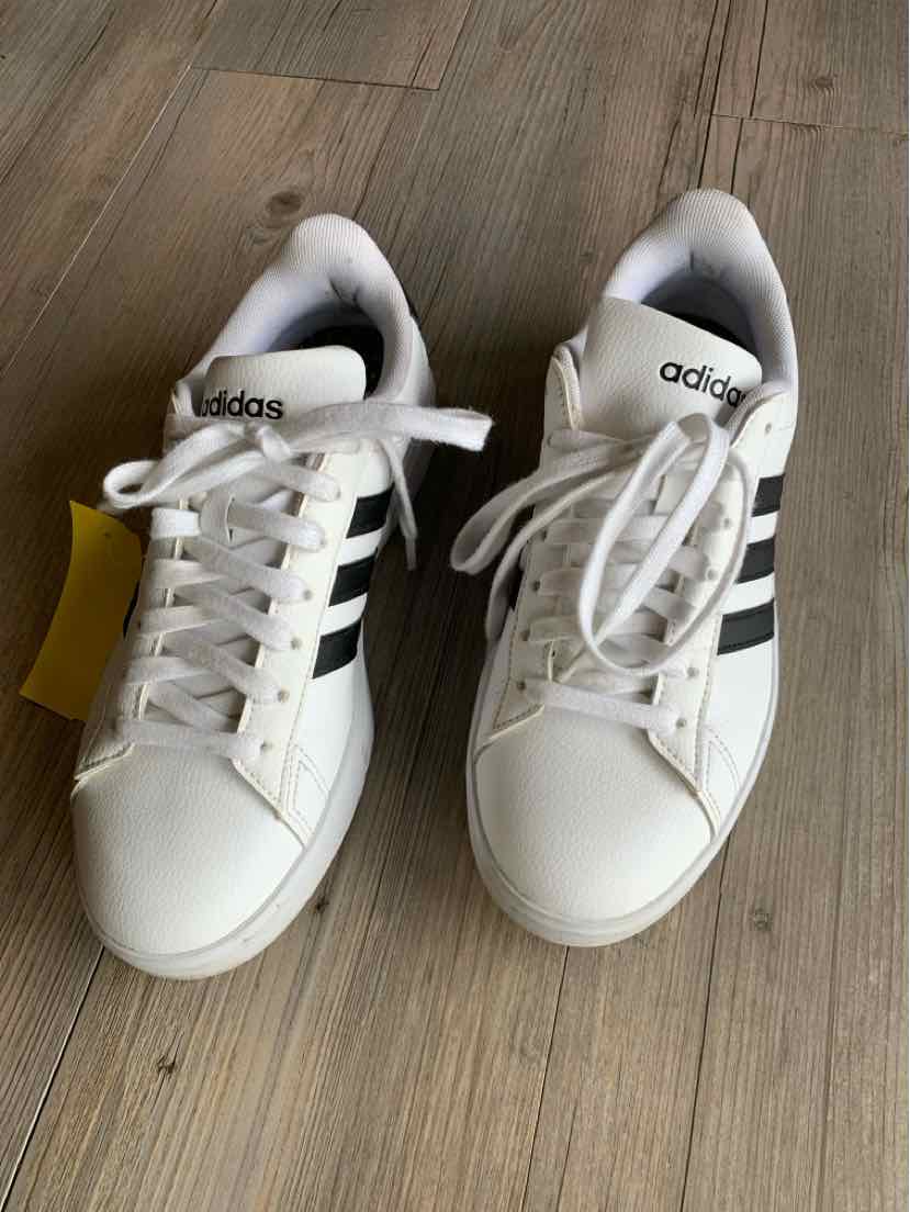 White Adidas sneakers with black stripes, lace-up design, and rounded toe, size 7.5.