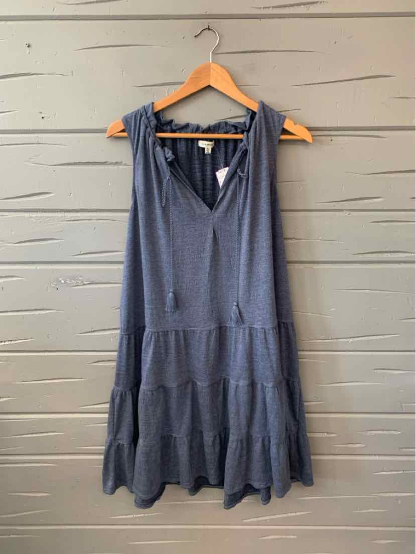 Sleeveless navy blue tiered dress with a V-neck and relaxed fit hanging on wooden hanger.