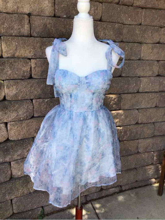 Light blue floral print sleeveless dress with ruffled straps and fitted bodice on mannequin.
