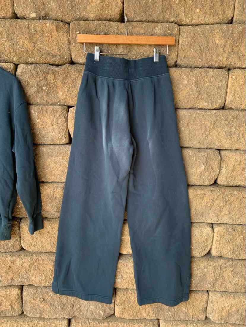 Navy blue wide-leg pants with elastic waistband, made from soft fabric, hanging on wooden hanger.