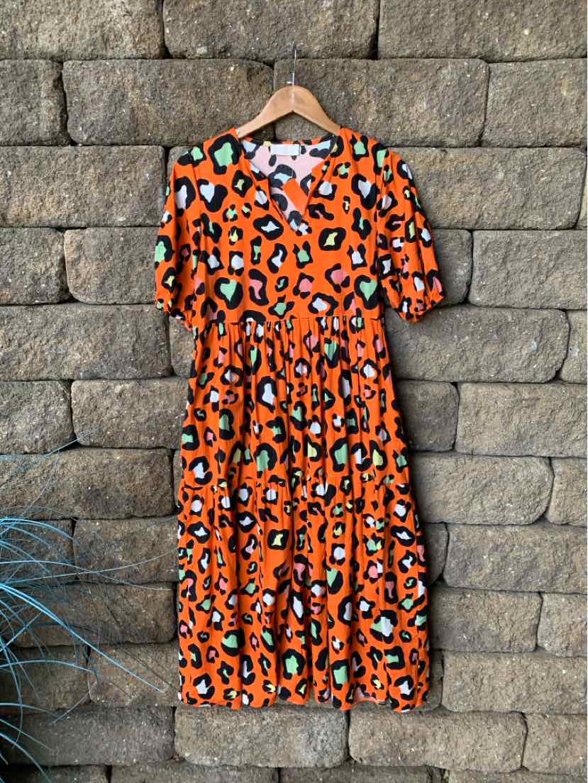 Orange midi dress with black and white leopard print, short puff sleeves, and gathered waist.