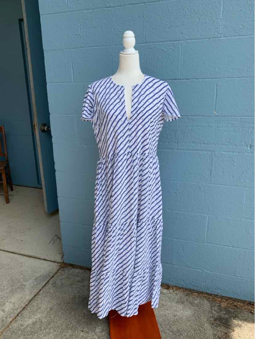 White midi dress with navy diagonal stripes, short sleeves, and a front slit neckline on a mannequin.