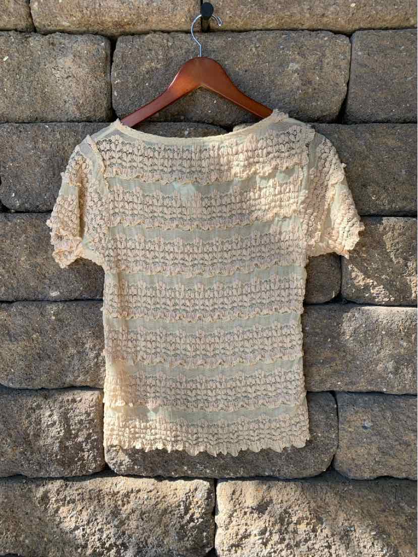 Tan lace short-sleeve top with scalloped edges and a delicate crocheted pattern, size large.