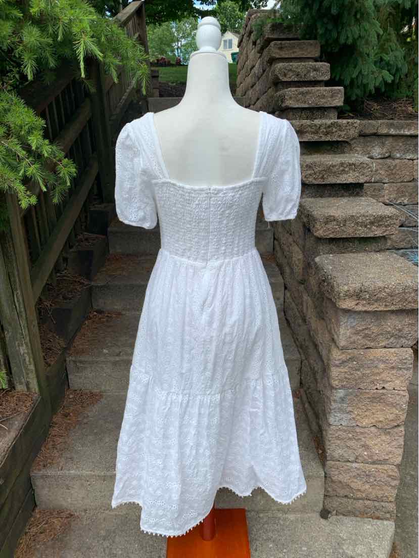 White eyelet midi dress with puff sleeves and fitted smocked bodice.