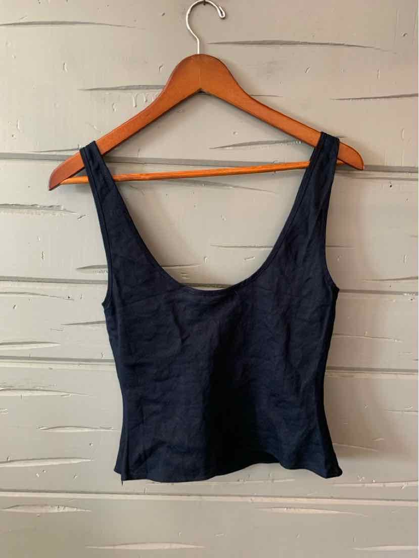Black sleeveless tank top with scoop neckline and fitted waist on a wooden hanger.