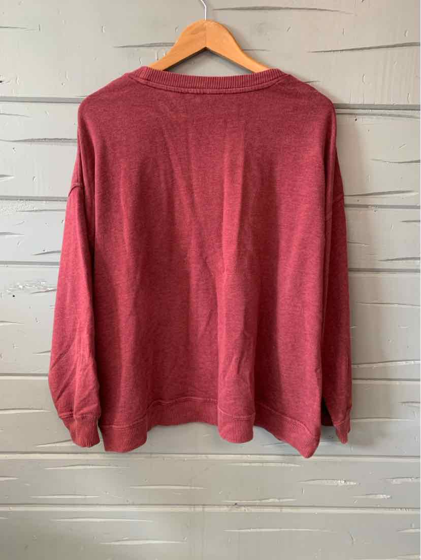 Long-sleeve burgundy crewneck sweatshirt with a relaxed fit hanging on a wooden hanger.