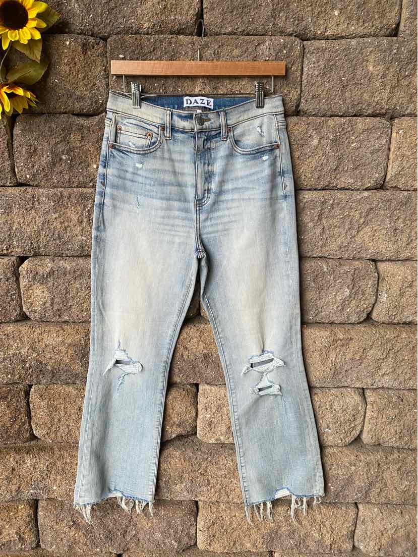 Light blue distressed denim jeans with ripped knees and frayed hems, cropped length.