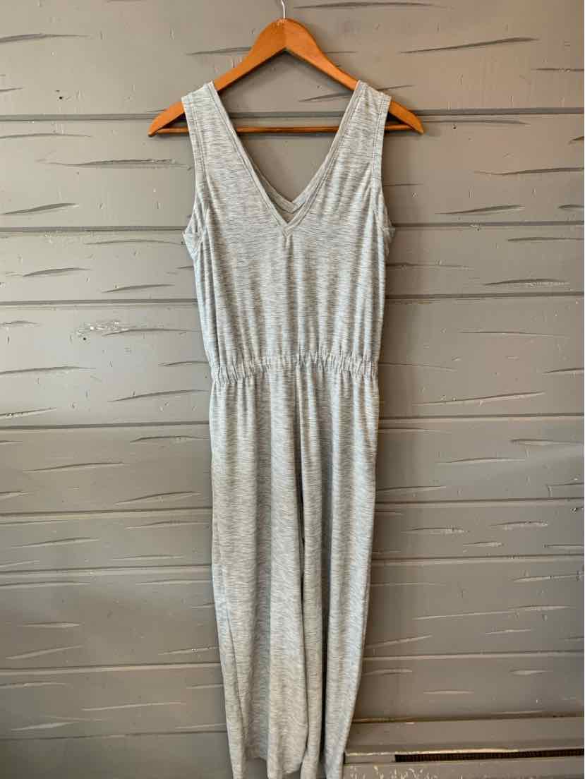 Light gray sleeveless jumpsuit with V-neck and elastic waist, made of soft knit fabric.