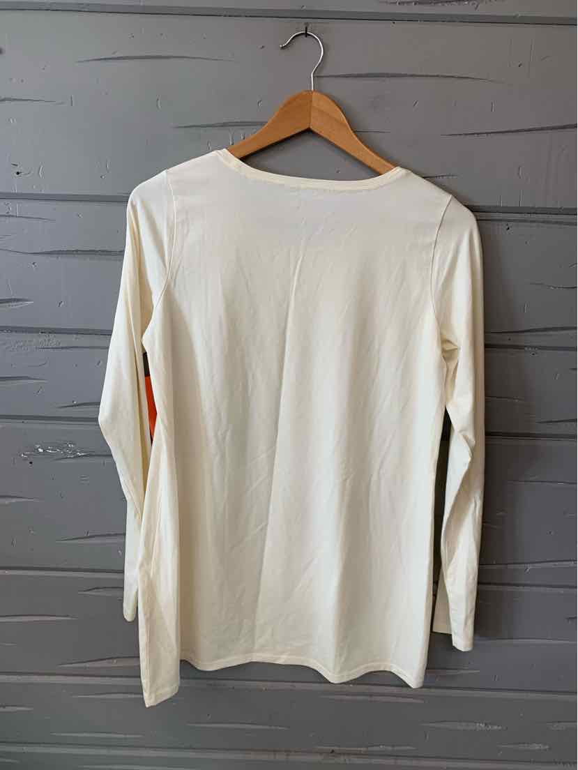 Long-sleeve white crew neck shirt with a relaxed fit hanging on wooden hanger against gray background.