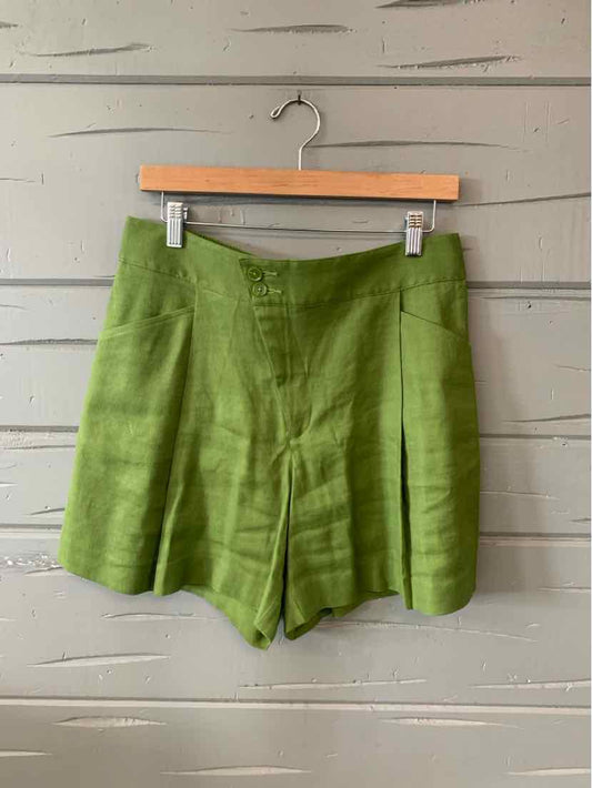 Green single button shorts hanging on gray wall