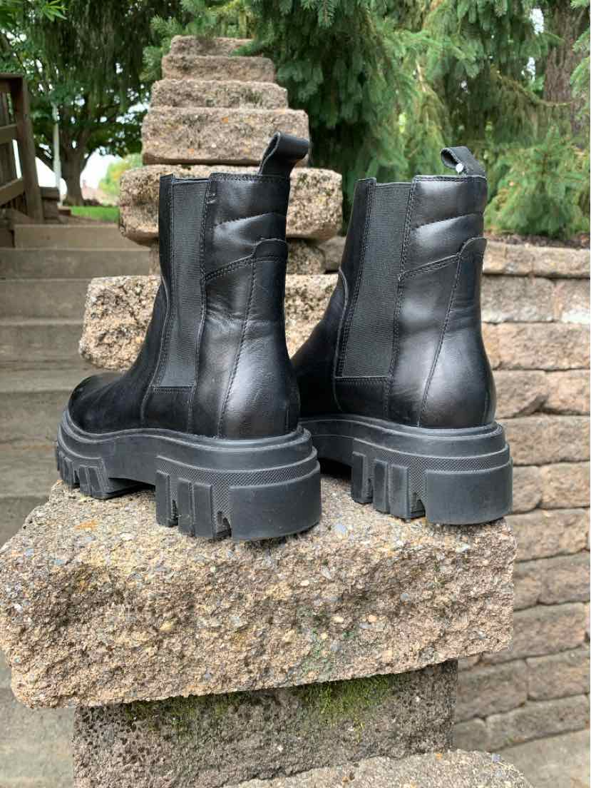 Black leather ankle boots with chunky lug soles and pull tabs at the back.