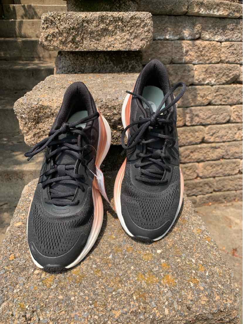 Women's black athletic sneakers with mesh upper, black laces, and white sole, size 7.