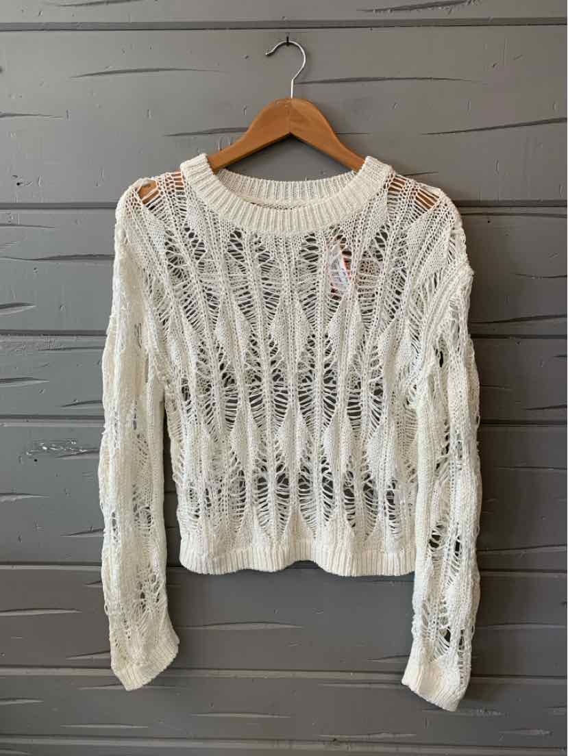 White long-sleeve knit sweater with open weave pattern and crew neckline on wooden hanger.