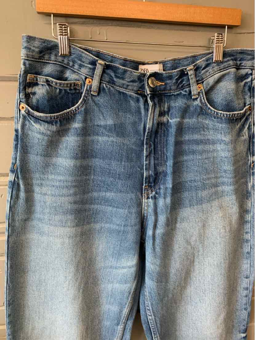 Blue denim jeans with front pockets, button closure, and faded wash detailing.