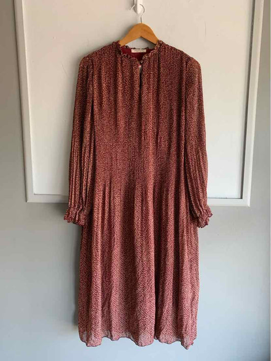 Burgundy midi dress with delicate floral print, long sleeves, gathered cuffs, and a round neckline with button details.