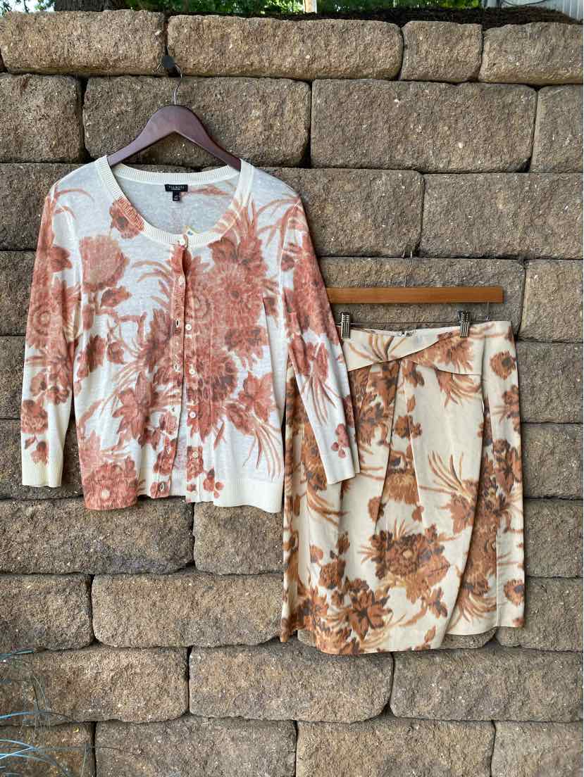 White cardigan and matching skirt set with large rust and beige floral print, medium size, lightweight knit fabric.