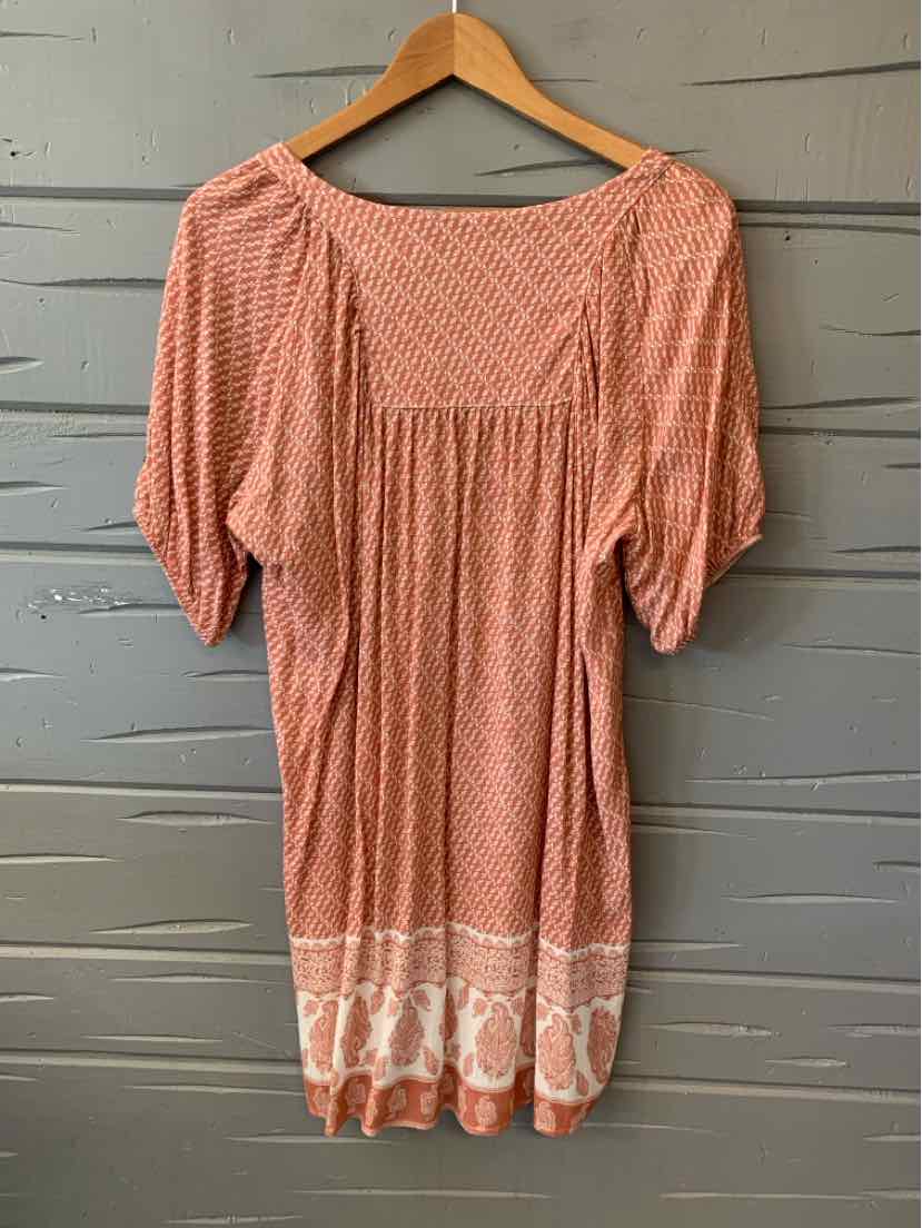 Light coral pink blouse with white paisley pattern, square neckline, and puffed short sleeves.