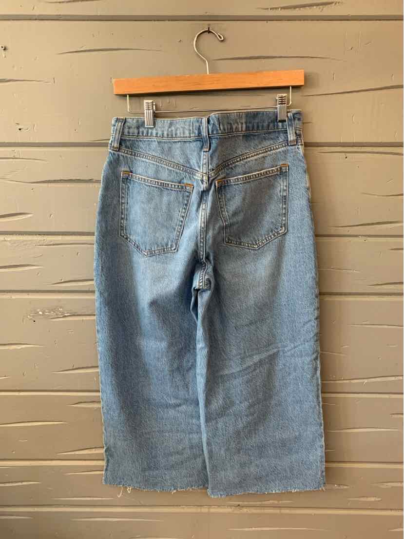 Light wash denim skirt with rear pockets and frayed hem, size 4S.