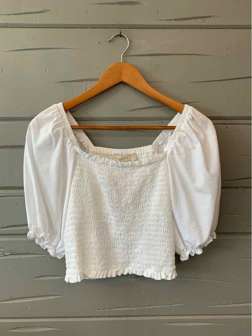White textured knit blouse with puffed three-quarter sleeves and square neckline on wooden hanger.
