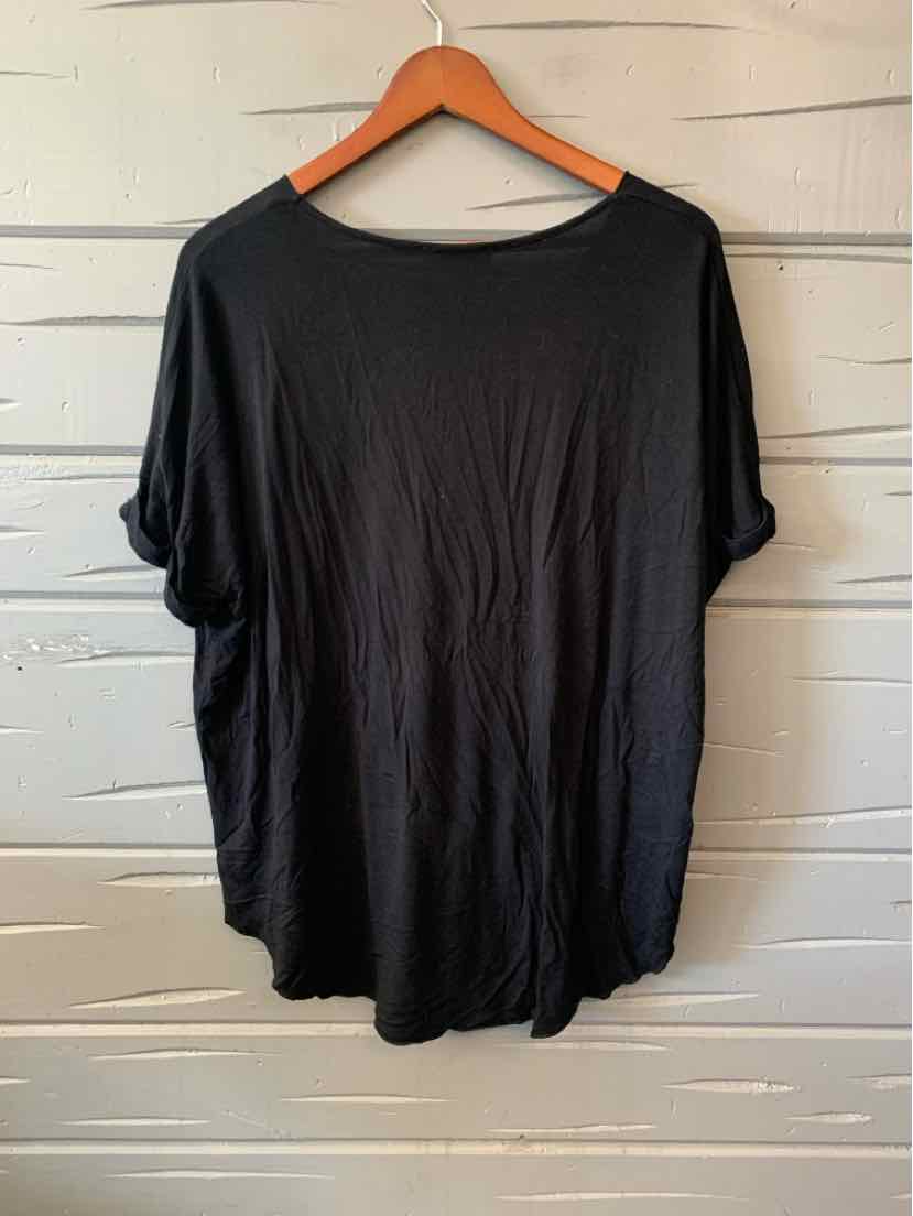 Black casual women's top with short sleeves and relaxed fit hanging on wooden hanger.