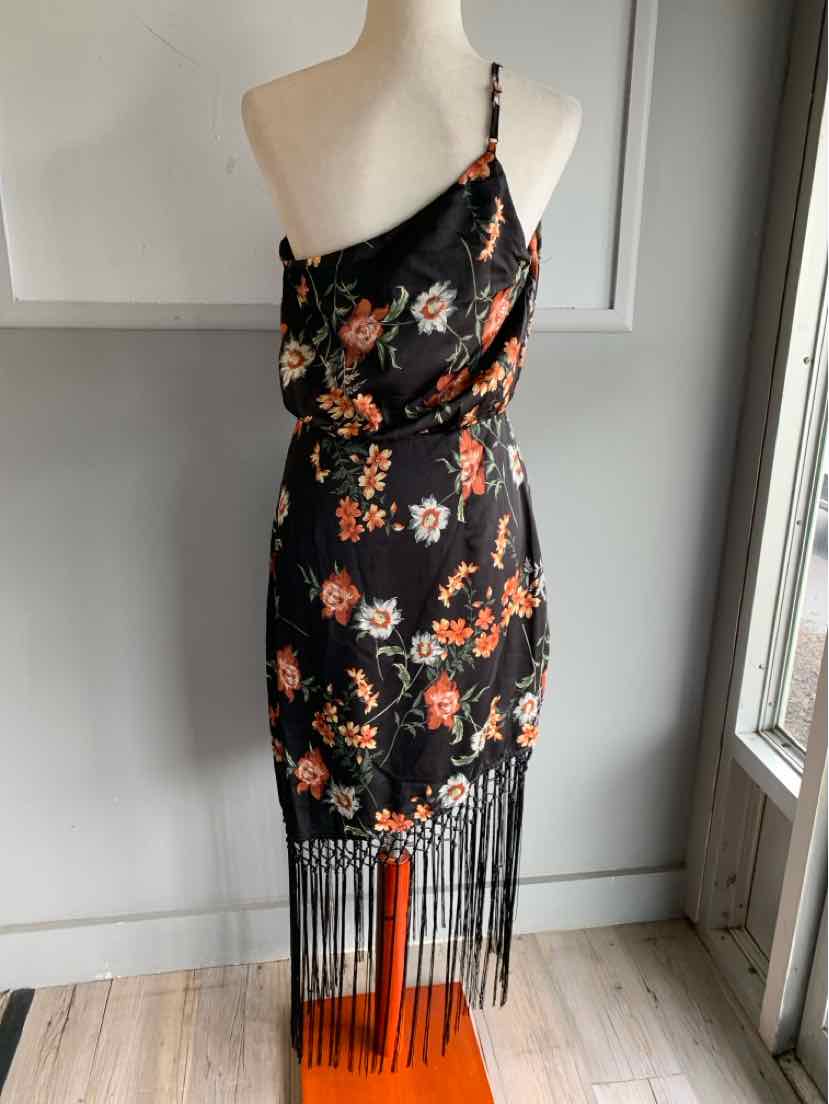 Black asymmetrical one-shoulder dress with orange floral print and long fringe hem.