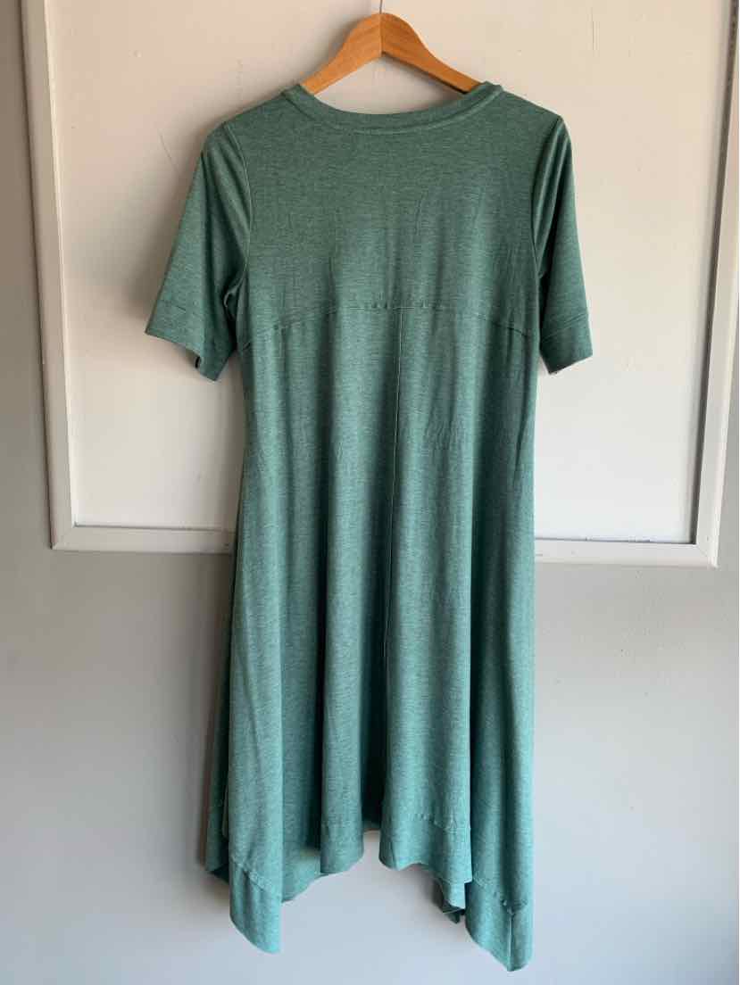 Teal short-sleeve dress with a relaxed fit and asymmetrical hem hanging on wooden hanger.