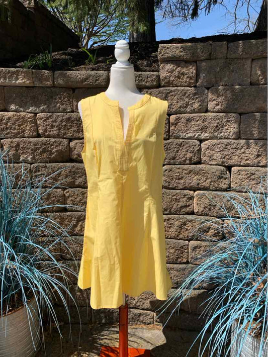 Yellow sleeveless knee-length dress with V-neck and front buttons on mannequin.