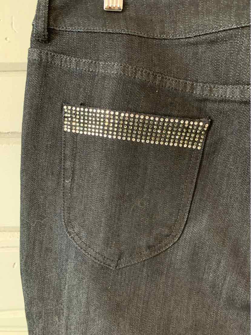 Dark gray denim jeans back pocket with decorative rhinestone trim along the top edge.