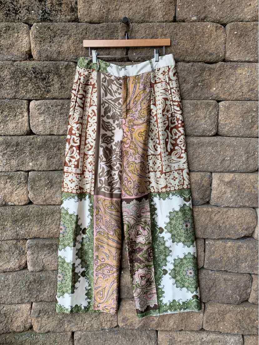 Wide-leg patchwork pants with mixed floral and geometric prints in green, brown, cream, and mustard tones.