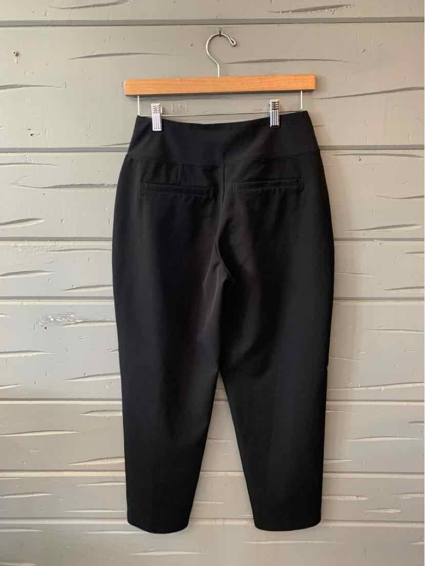 Black high-waist tapered pants with back welt pockets and a fitted ankle hem.