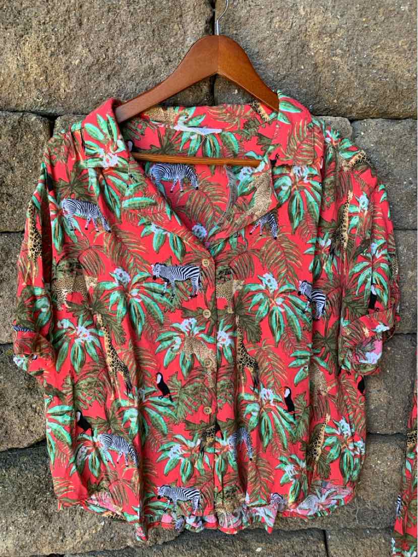 Red button-up blouse with tropical floral print, short puffed sleeves, and gathered hem.