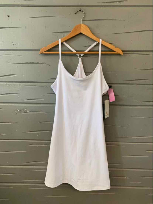 White sleeveless dress with thin straps and a relaxed fit hanging on wooden hanger.