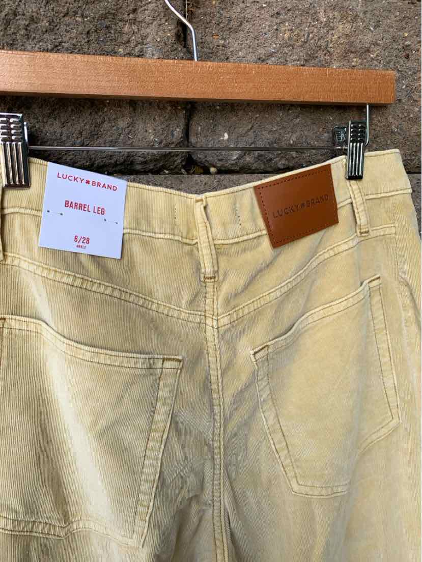 Tan denim jeans size 6 with back pockets and a brown leather Lucky Brand patch on the waistband.
