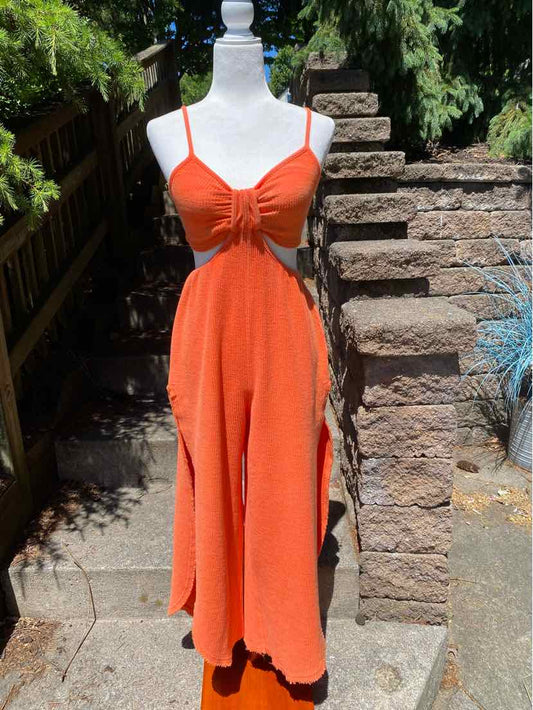 Orange sleeveless midi dress with spaghetti straps and a ruched bust on a white mannequin outdoors.
