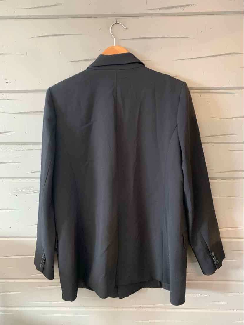 Black long-sleeve blazer with structured shoulders and single back vent, hanging on wooden hanger.