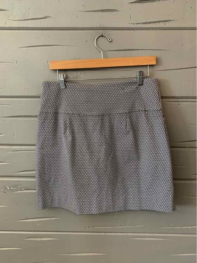 Gray patterned skort with a straight silhouette and flat waistband hanging on wooden hanger.