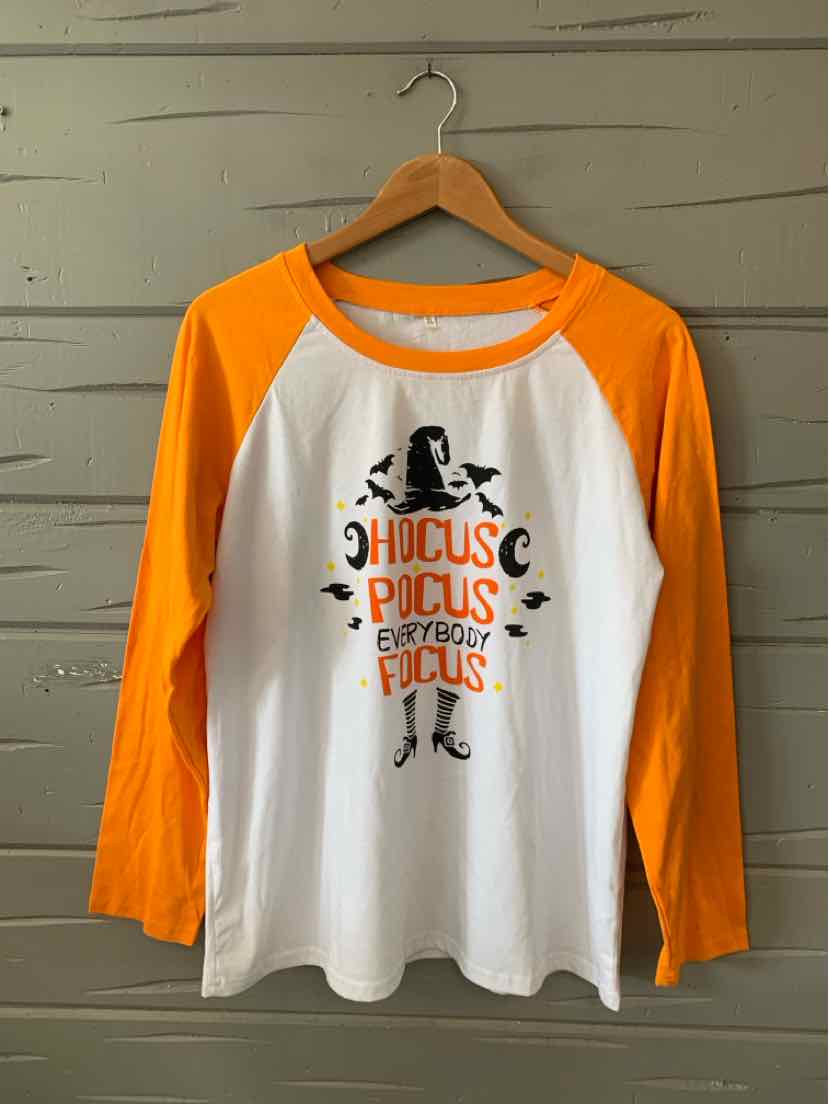White and orange long-sleeve raglan shirt with Halloween-themed graphic and text on front.