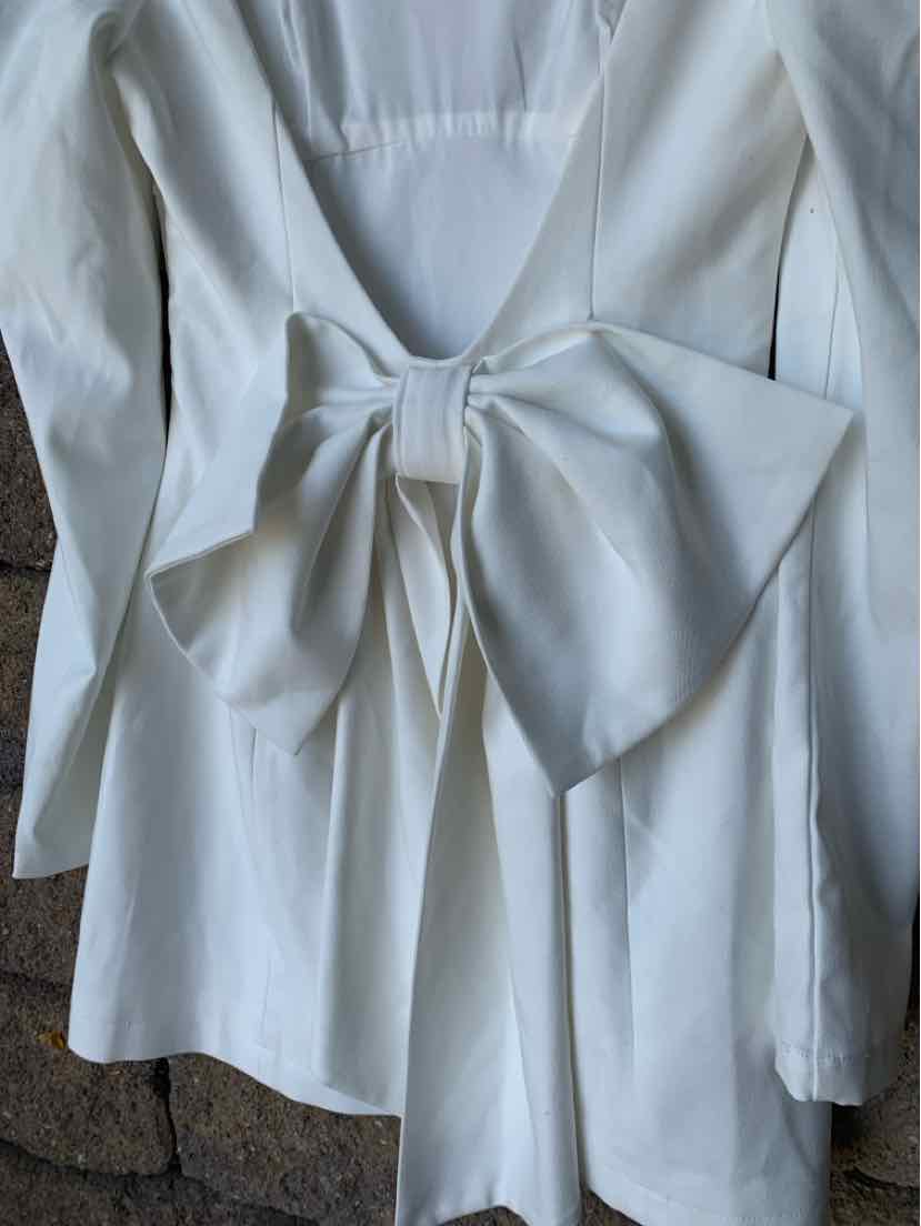 White long-sleeve dress with deep V-back and large bow detail at waist, size XS.