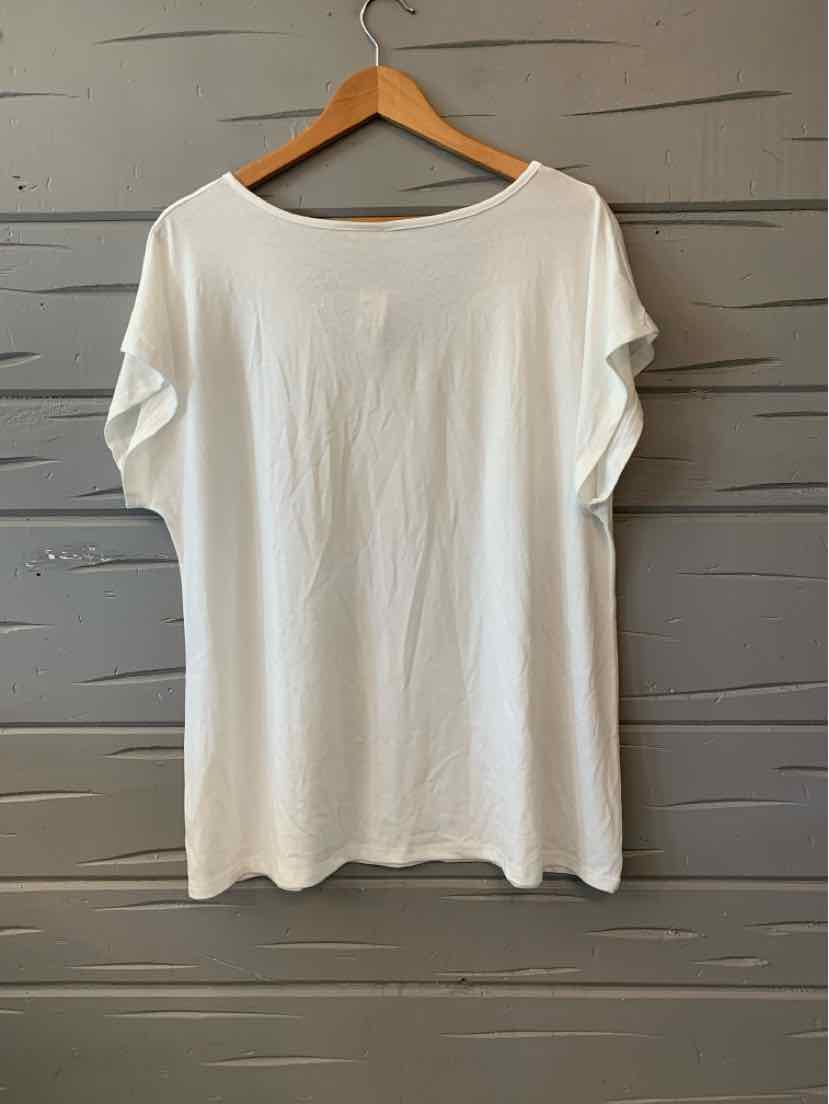 White oversized short-sleeve T-shirt with round neckline hanging on wooden hanger.