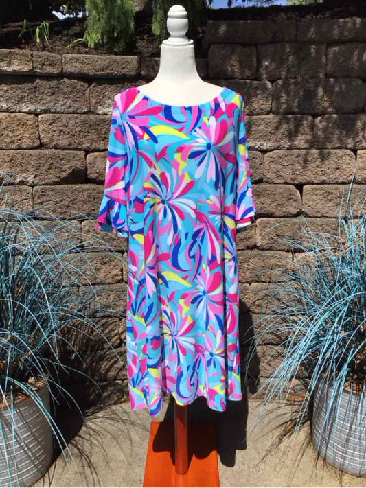 Colorful knee-length dress with abstract floral pattern in blue, pink, purple, and green, featuring 3/4 sleeves and a scoop.