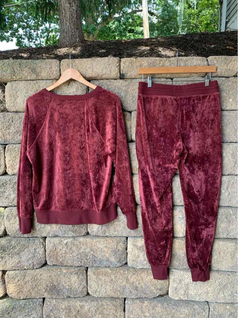 Two-piece set with long-sleeve crewneck top and jogger pants in soft burgundy plush fabric.