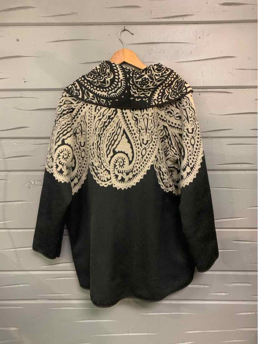 Black long-sleeve blouse with large paisley print and wide collar on hanger.