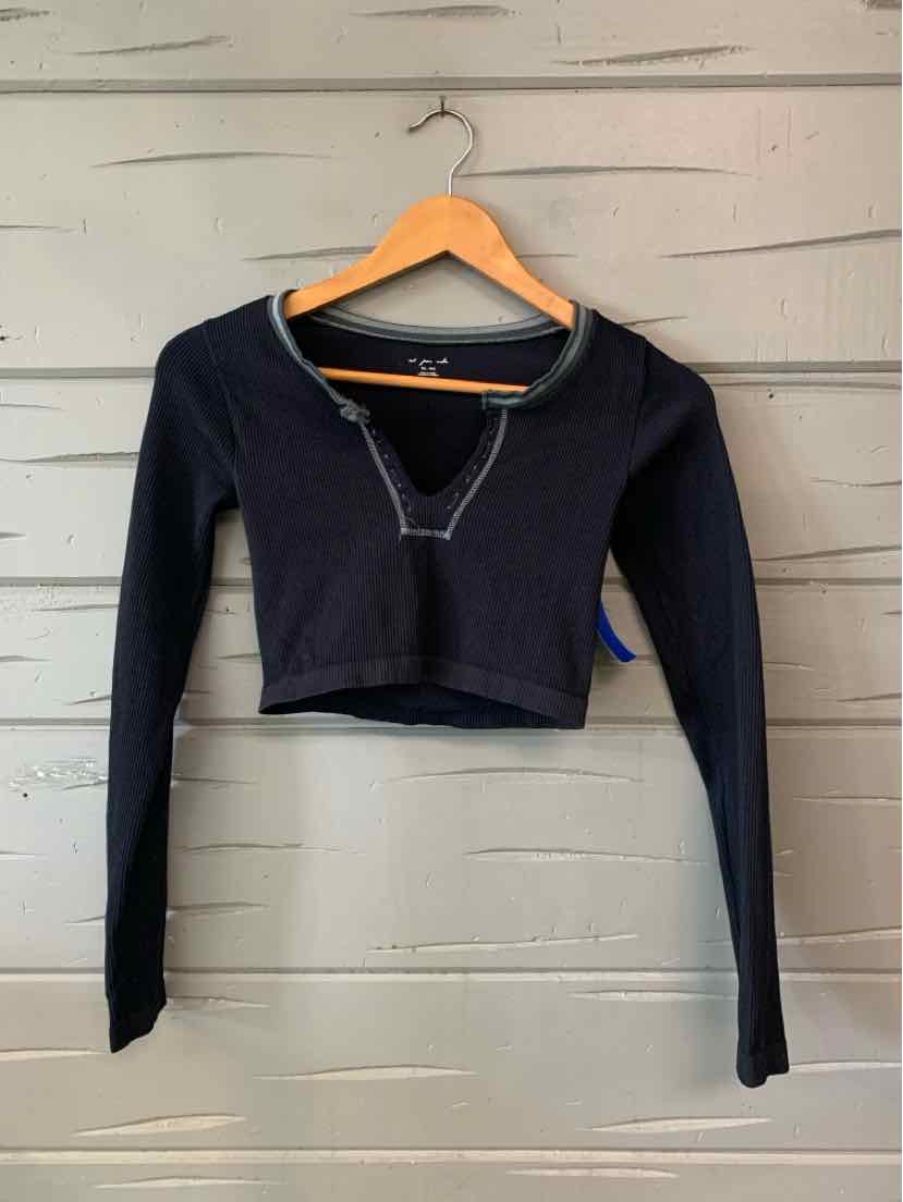 Black long-sleeve cropped top with a wide neckline, fitted cuffs, and a small V-shaped neckline detail.