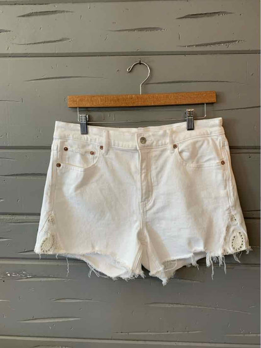 White denim shorts with frayed hems and lace detailing on the sides, size 4.