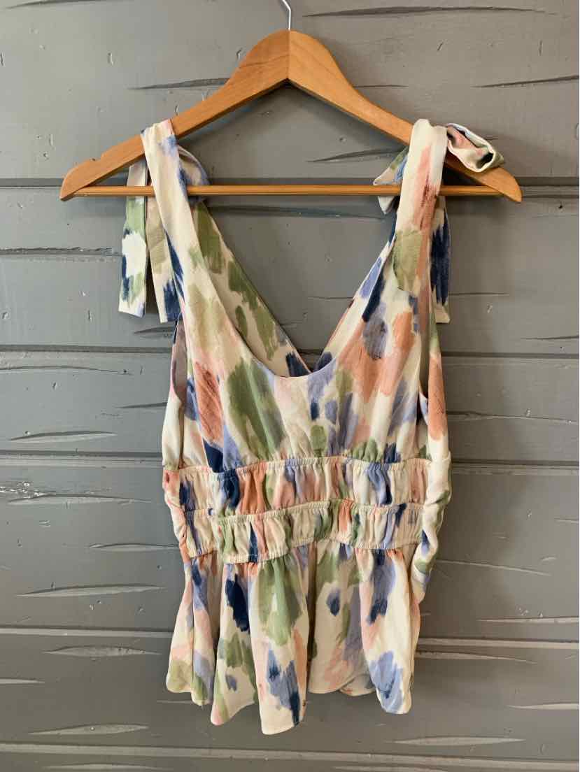 Sleeveless multi-color blouse with tie shoulder straps and ruched waist on wooden hanger.